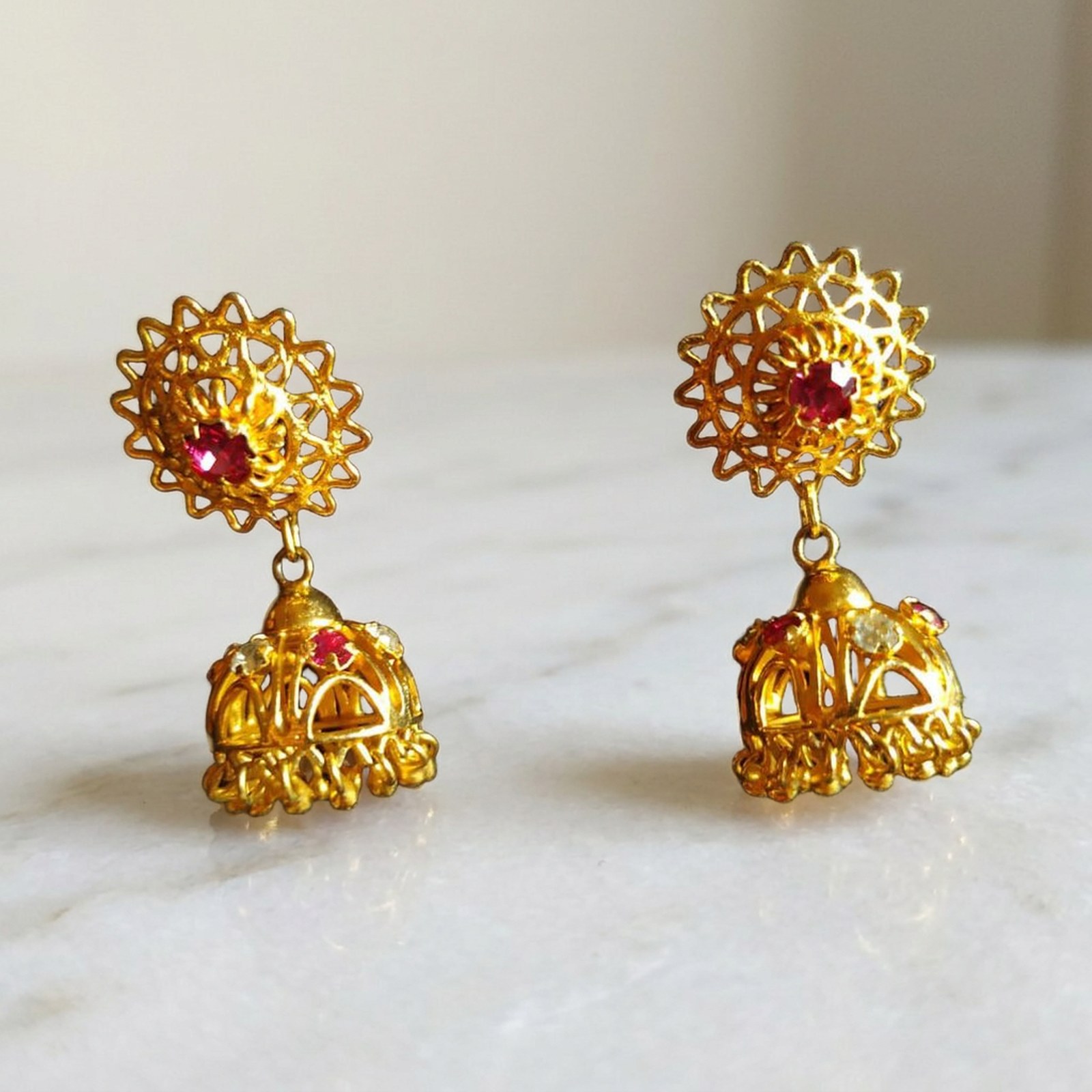 after: the same paired gold earrings in a styled jewelry photography scene