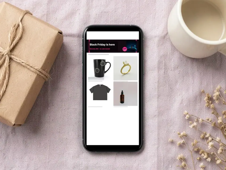 Phone on a linen cloth showing an Etsy shop page with a Black Friday banner