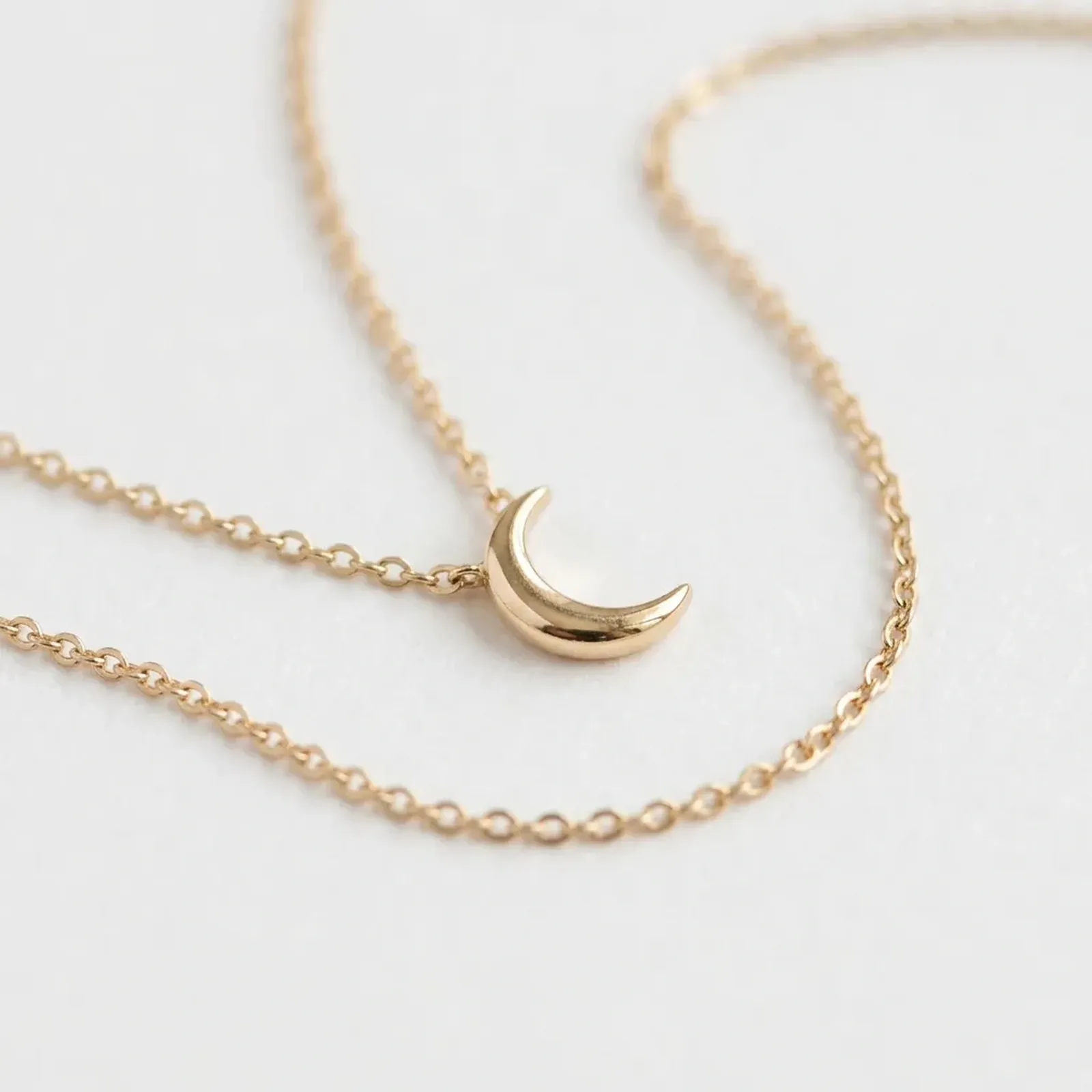 before: original product photo of a gold crescent-moon necklace