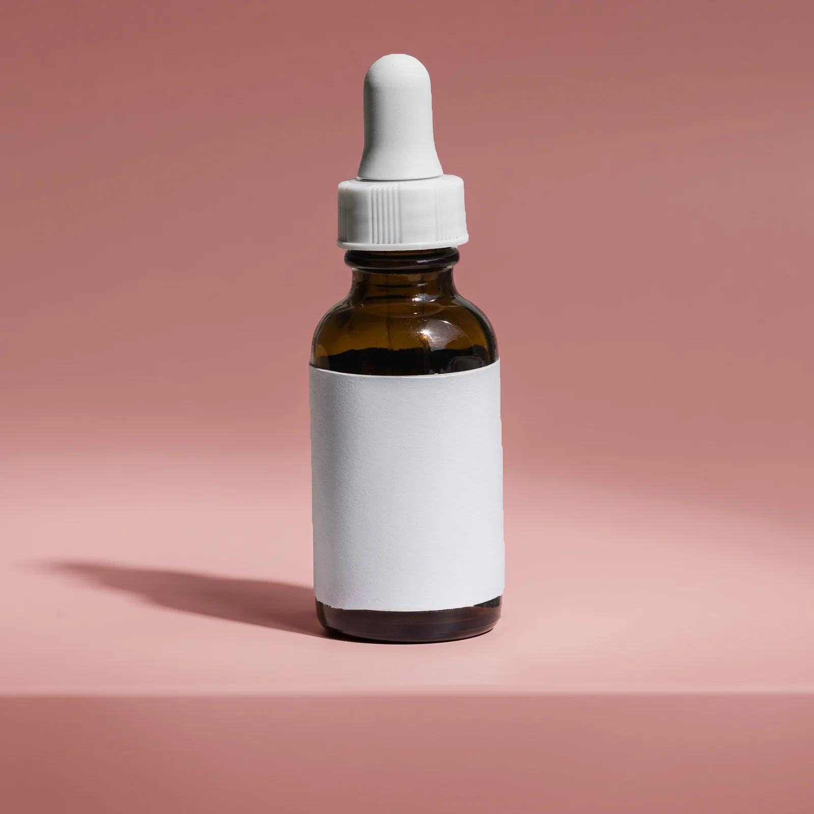 unbranded skincare bottle against a rose backdrop