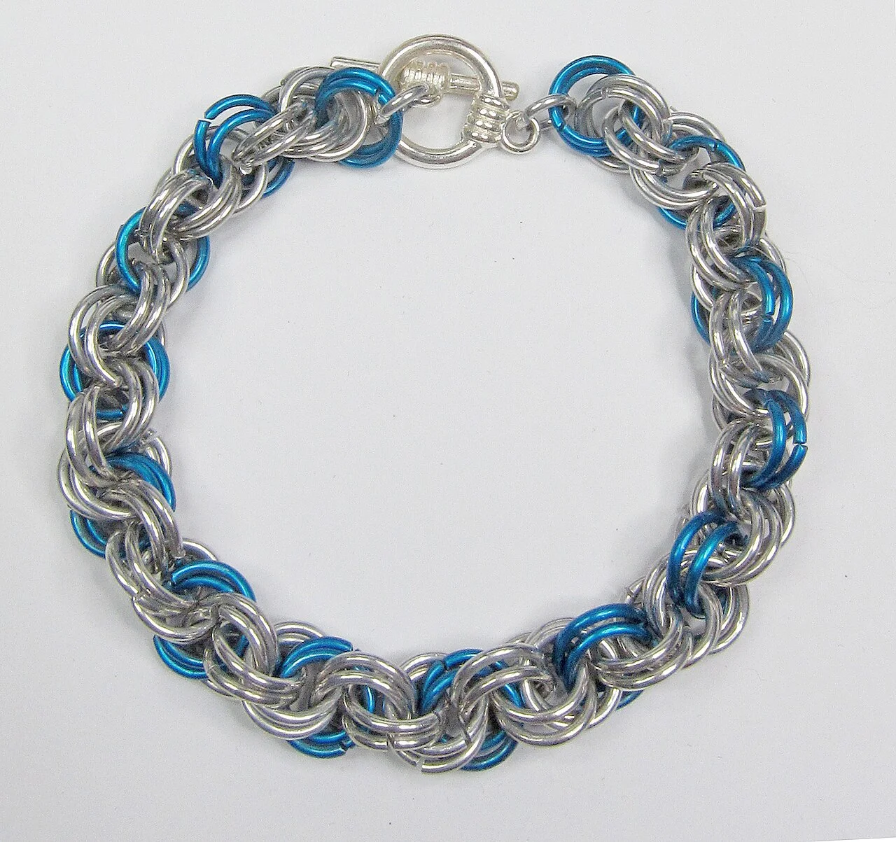 before: silver and blue bracelet on a grey display