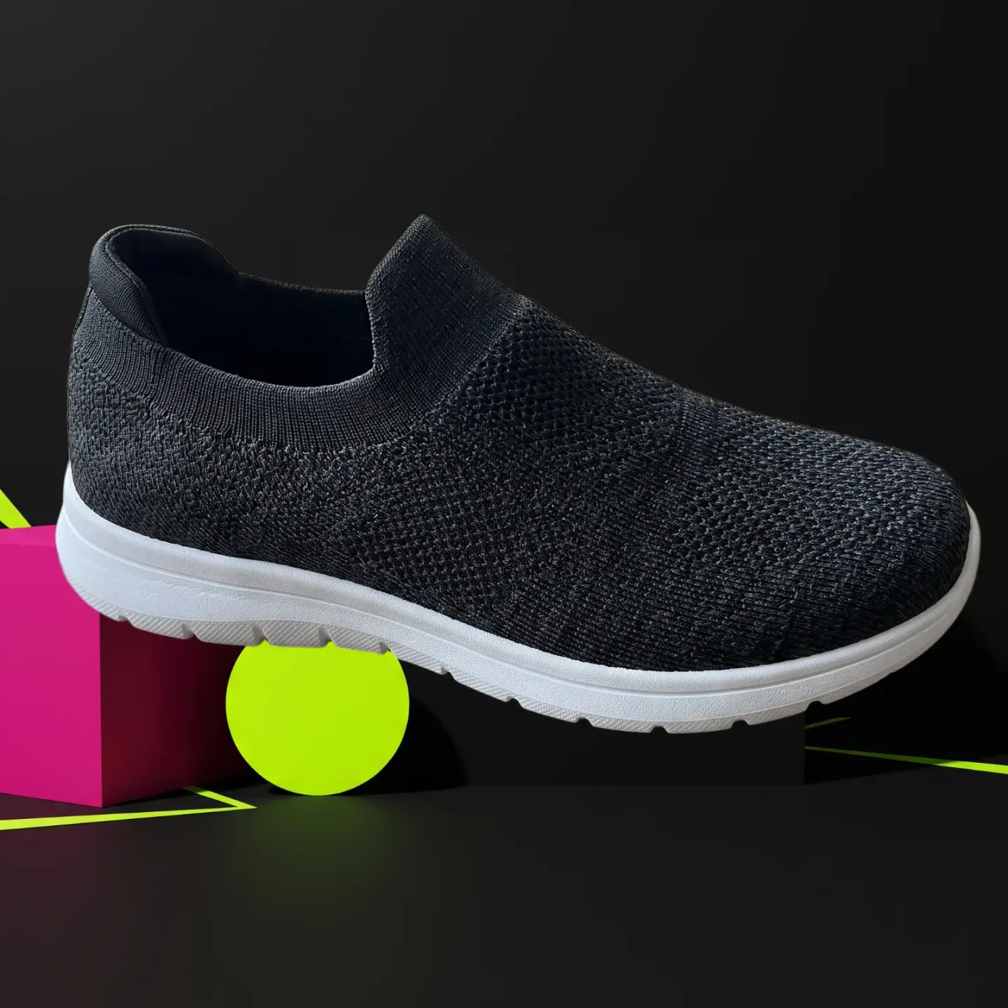 Sneaker on a pink block with a yellow-green circle on black, a limited drop scene