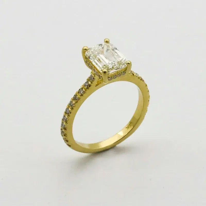 A gold ring with an emerald-cut stone, plain product photo