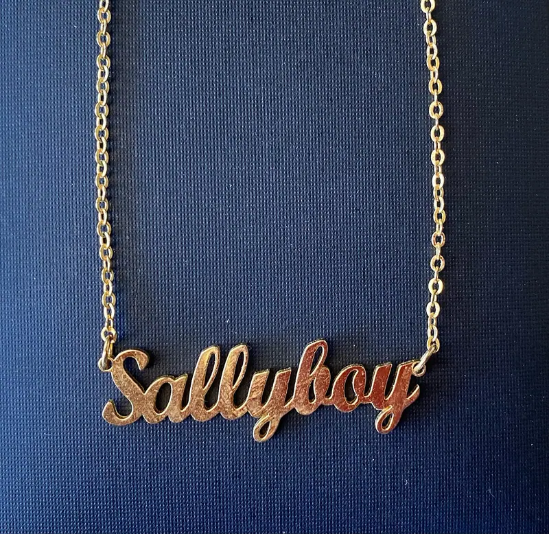 before: gold name necklace and fine chains photographed against dark blue fabric