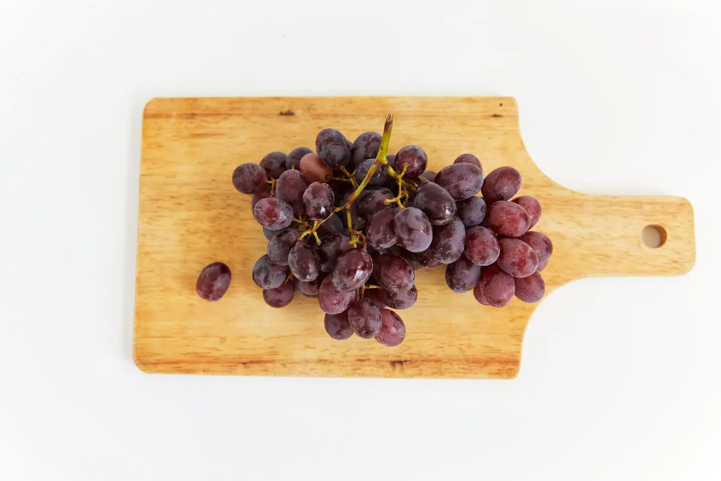 bunch of red grapes on a wooden board, product photo on white
