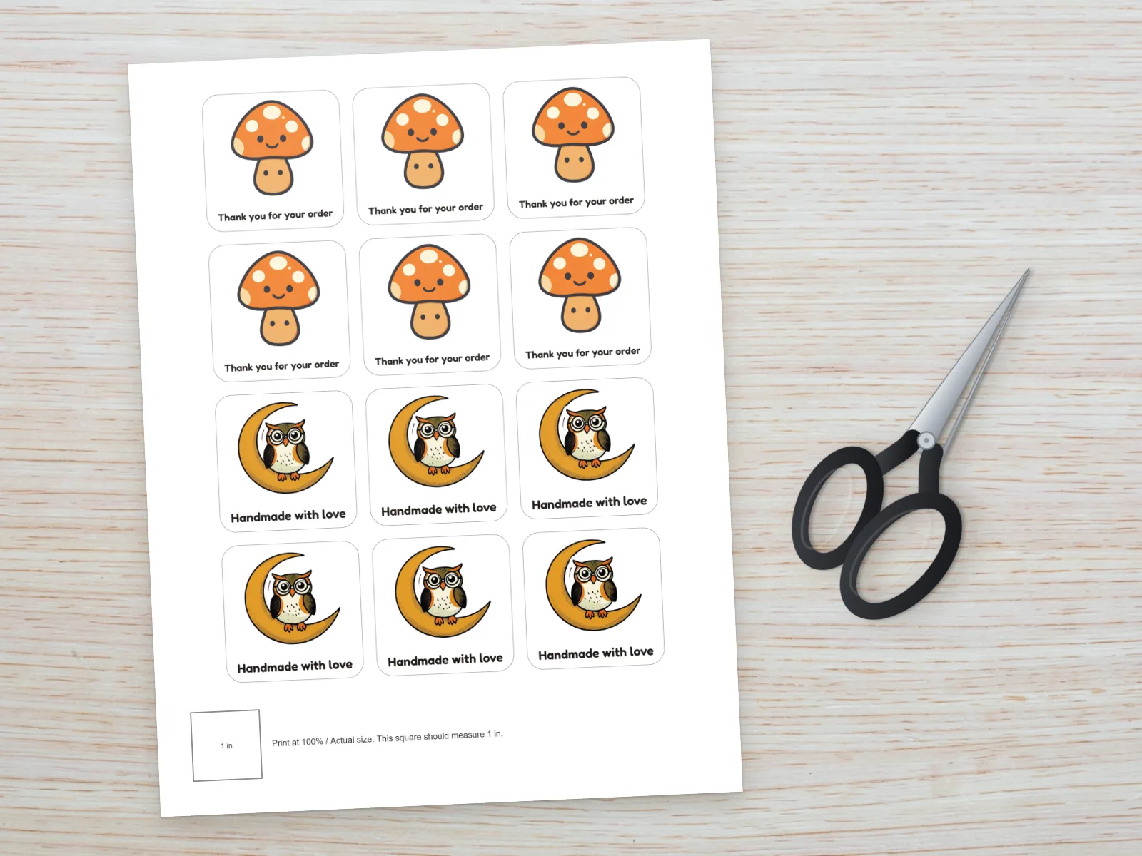 Printed test sheet of mushroom and owl stickers beside scissors with a calibration square